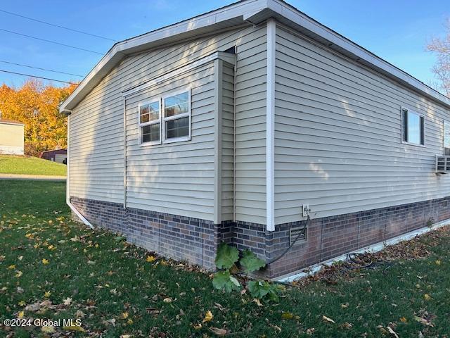 view of side of home with a yard