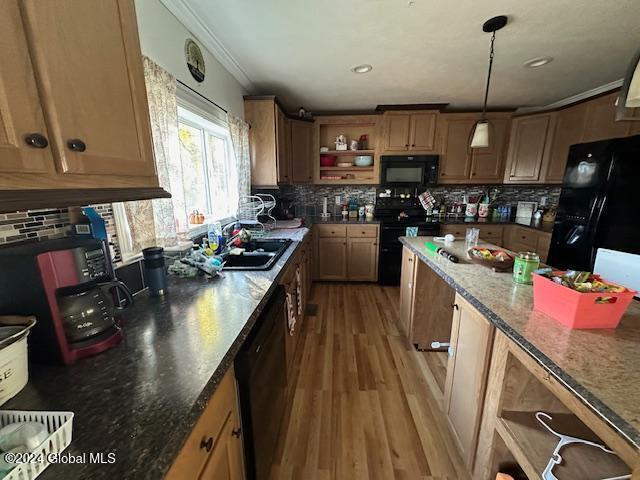 kitchen featuring tasteful backsplash, black appliances, sink, and wood-type flooring