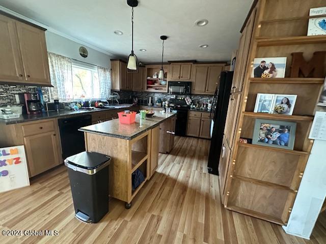 kitchen featuring decorative backsplash, light hardwood / wood-style flooring, black appliances, decorative light fixtures, and a center island