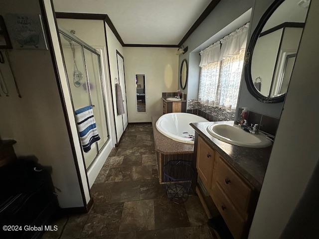 bathroom featuring vanity, crown molding, and plus walk in shower