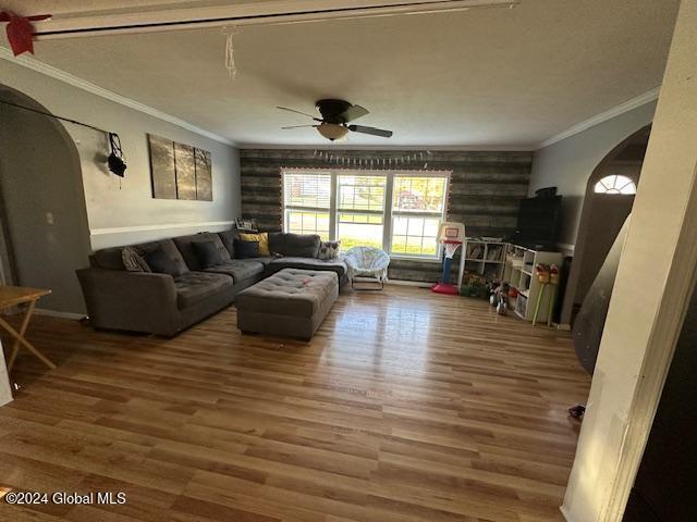 living room with ornamental molding, hardwood / wood-style flooring, and ceiling fan