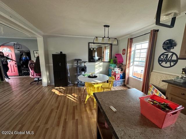 dining space with crown molding and hardwood / wood-style flooring