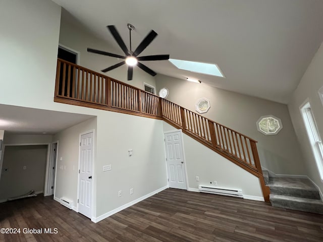 stairway with hardwood / wood-style floors, a baseboard heating unit, ceiling fan, and a skylight