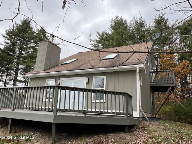 rear view of property featuring a wooden deck