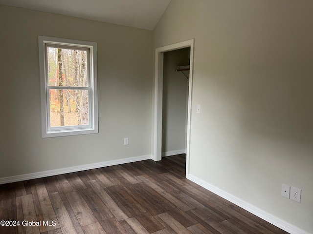 empty room featuring dark hardwood / wood-style floors and vaulted ceiling