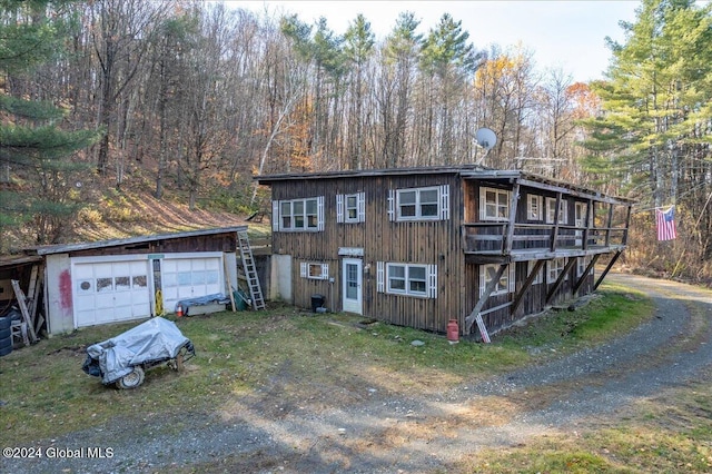 view of front of house featuring an outdoor structure, a deck, and a garage