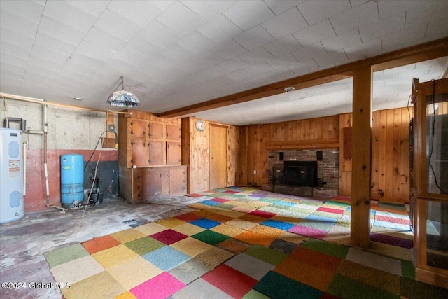 basement featuring a wood stove and water heater