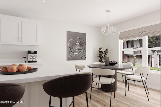 dining space with light wood-type flooring and an inviting chandelier