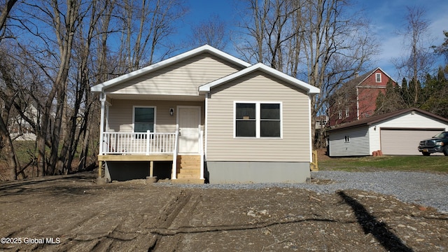 bungalow-style house with a porch, an outdoor structure, and a detached garage