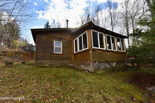 view of property exterior featuring a yard and a sunroom