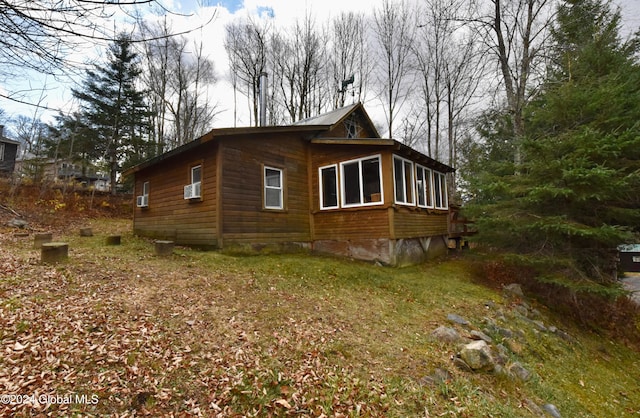 view of side of home featuring a sunroom and cooling unit