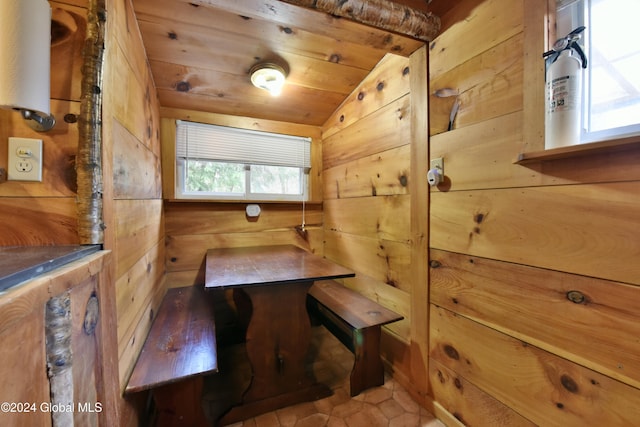 tiled dining area featuring wood ceiling, lofted ceiling, and wooden walls