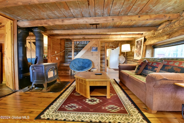 living room featuring hardwood / wood-style flooring, a wood stove, and wooden ceiling