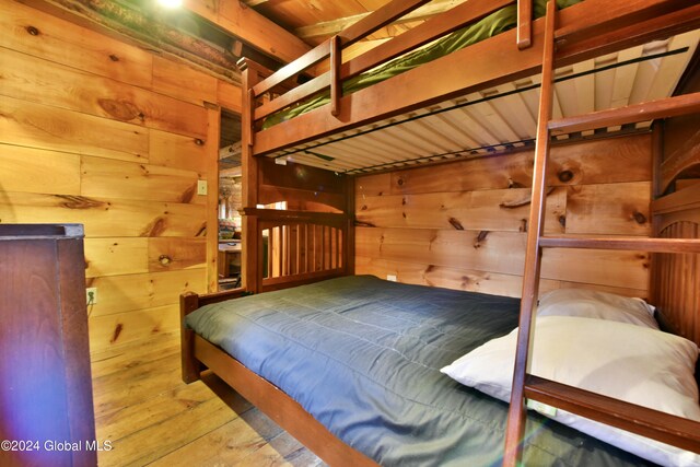 bedroom with wood ceiling, wood-type flooring, and wood walls