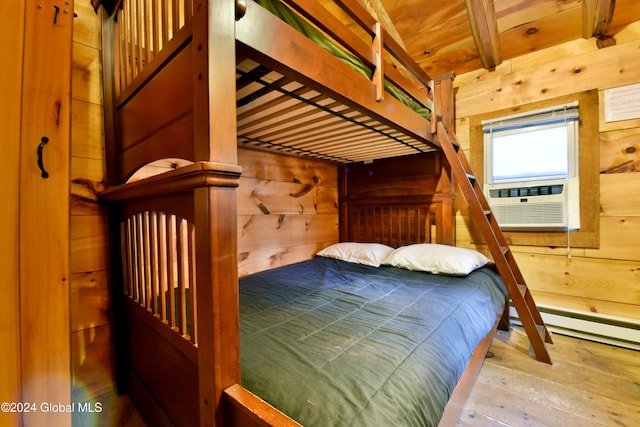 bedroom featuring light hardwood / wood-style floors, cooling unit, wood walls, and beamed ceiling