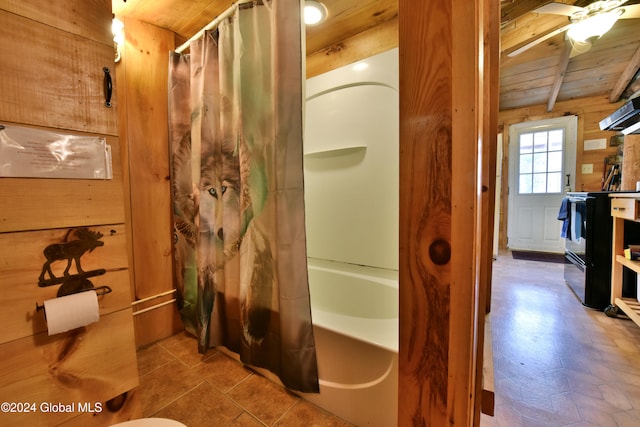 bathroom with beamed ceiling, shower / bath combination with curtain, wooden ceiling, ceiling fan, and wood walls