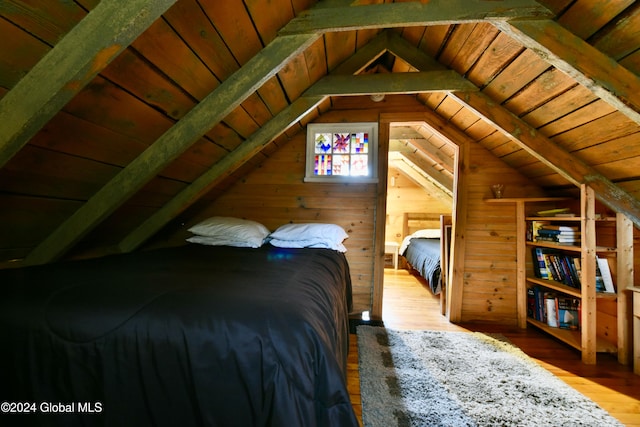 bedroom with vaulted ceiling with beams, hardwood / wood-style floors, and wooden ceiling