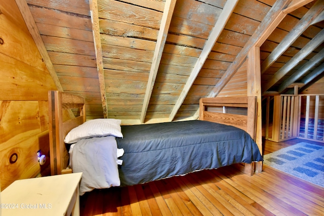 bedroom with vaulted ceiling, hardwood / wood-style flooring, and wooden ceiling