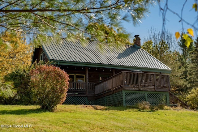 back of house featuring a wooden deck and a lawn