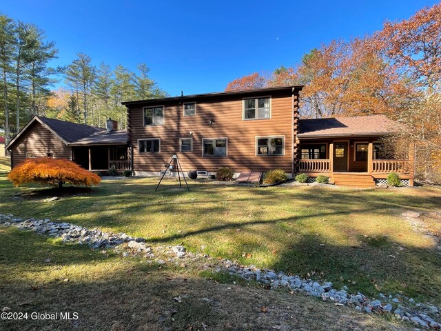 back of property featuring a deck and a yard