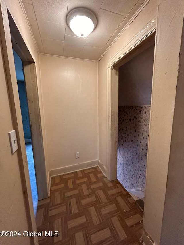 hallway featuring dark parquet floors and ornamental molding