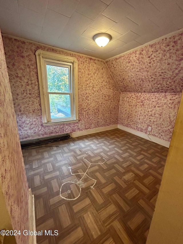 additional living space featuring dark parquet flooring and vaulted ceiling