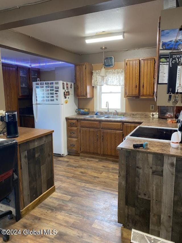 kitchen with light hardwood / wood-style floors, white fridge, sink, and pendant lighting