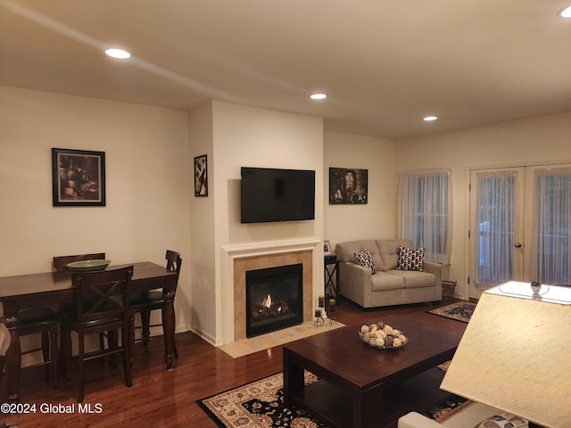 living room with dark wood-type flooring, french doors, and a tile fireplace