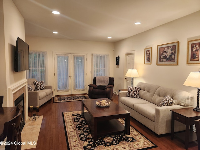 living room featuring french doors, hardwood / wood-style floors, and a tiled fireplace