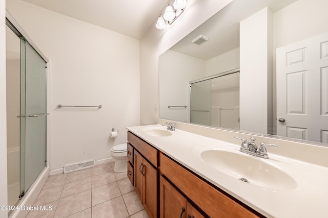 bathroom with tile patterned flooring, an enclosed shower, vanity, and toilet