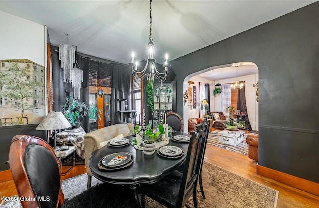 dining space with an inviting chandelier and hardwood / wood-style flooring