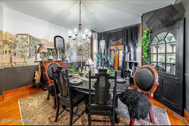 dining space with light hardwood / wood-style flooring and a chandelier