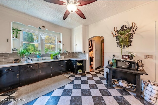 kitchen with white cabinetry, ceiling fan, decorative backsplash, and sink