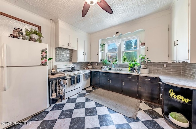 kitchen featuring sink, white cabinetry, ceiling fan, stainless steel appliances, and decorative backsplash