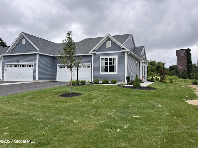 ranch-style home with roof with shingles, a front lawn, a garage, board and batten siding, and driveway