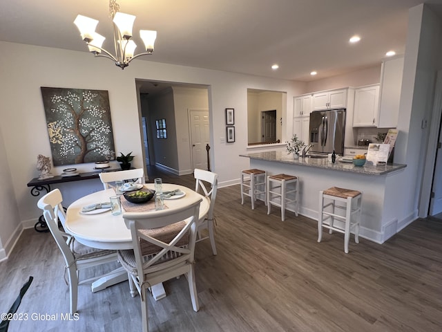dining room featuring dark wood-type flooring, recessed lighting, baseboards, and a notable chandelier