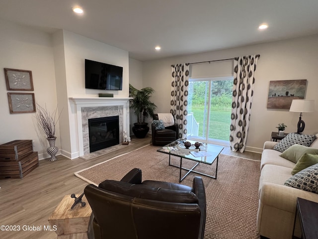 living room with recessed lighting, baseboards, wood finished floors, and a fireplace