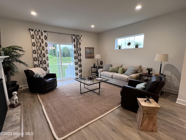 living room with recessed lighting, baseboards, wood finished floors, and a healthy amount of sunlight