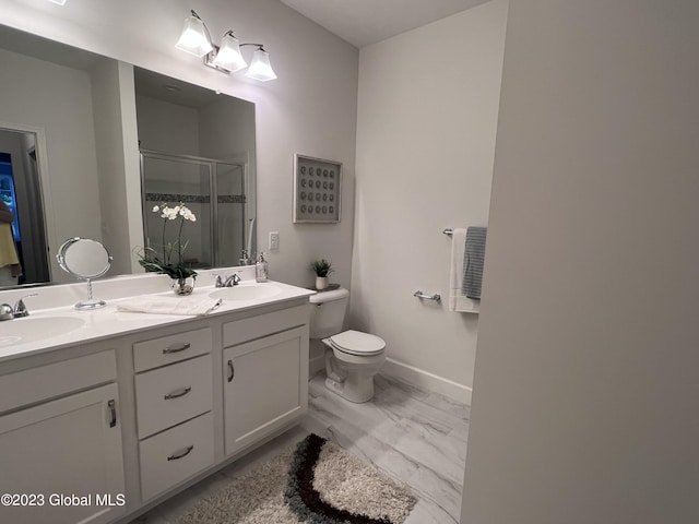 bathroom with a sink, a shower stall, toilet, and double vanity