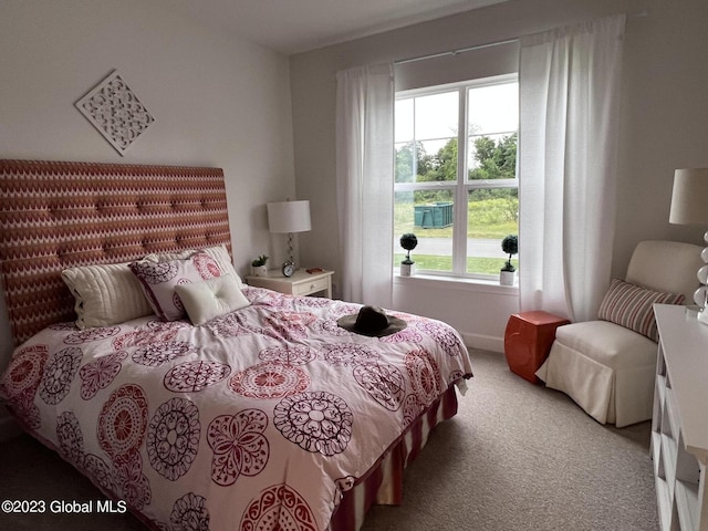 bedroom with light colored carpet and baseboards