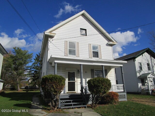 view of front of home with a front yard and a porch