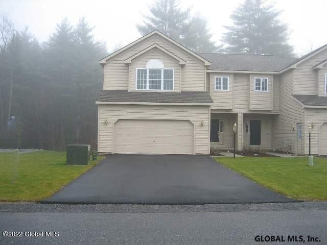 view of front of home with cooling unit, a front yard, and a garage