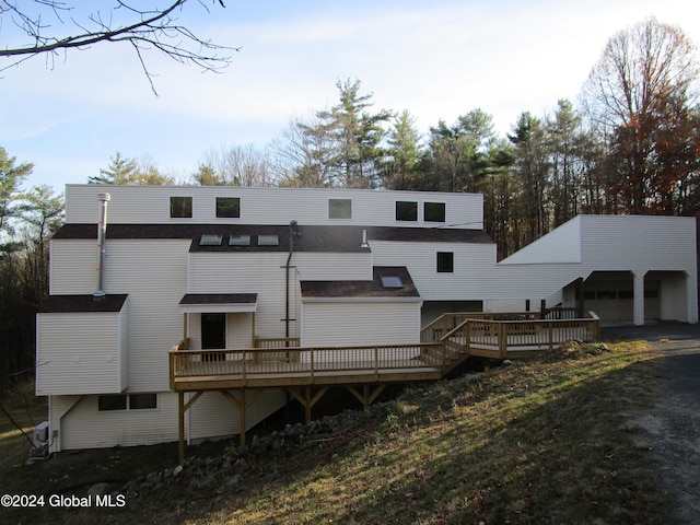 back of house with a garage and a deck