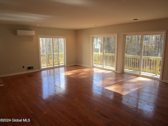 empty room featuring light hardwood / wood-style flooring and a wall mounted air conditioner