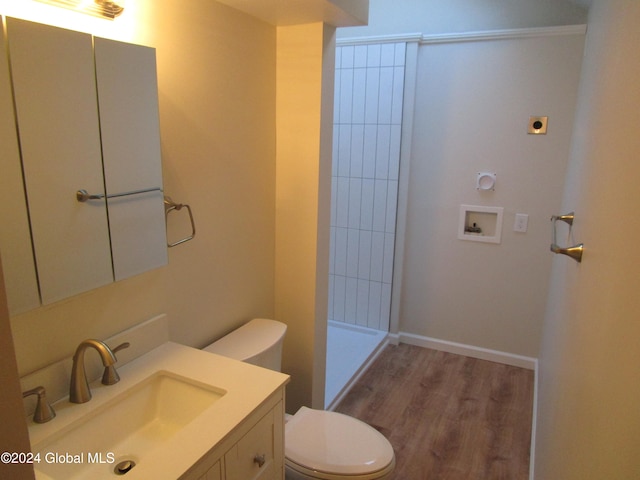 bathroom featuring walk in shower, vanity, hardwood / wood-style flooring, and toilet