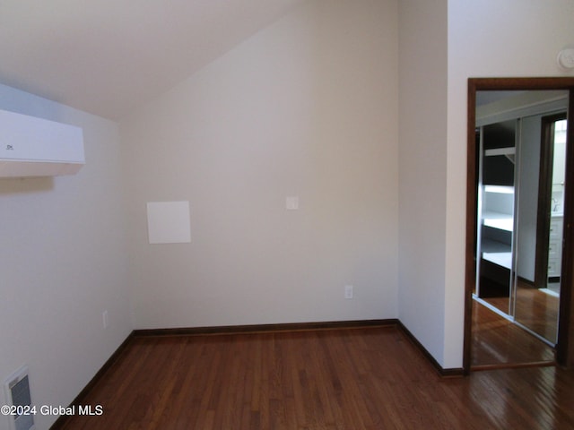 unfurnished room with dark wood-type flooring and lofted ceiling