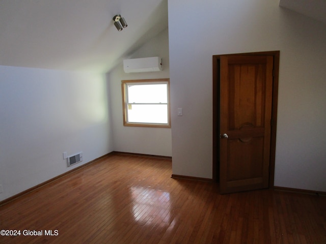 bonus room with dark hardwood / wood-style flooring, an AC wall unit, and vaulted ceiling