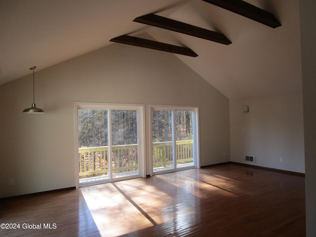 unfurnished living room featuring hardwood / wood-style flooring, a healthy amount of sunlight, and beam ceiling