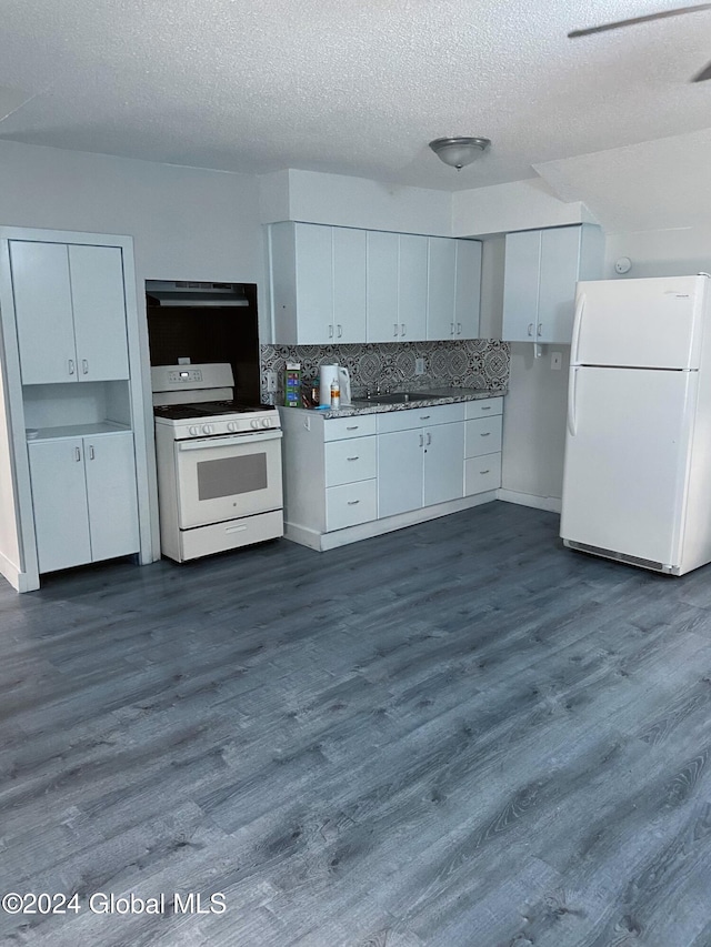 kitchen with white appliances, white cabinetry, and dark hardwood / wood-style flooring