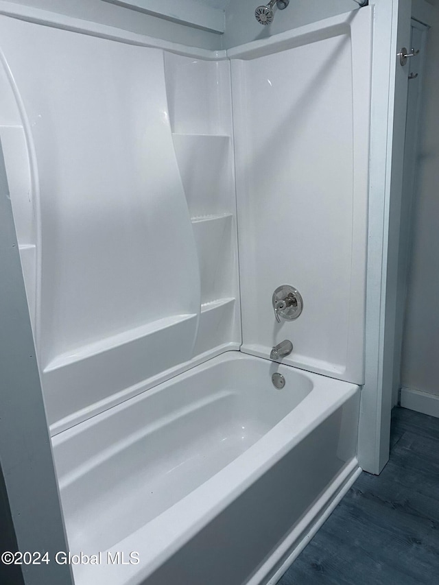 bathroom featuring hardwood / wood-style floors and  shower combination